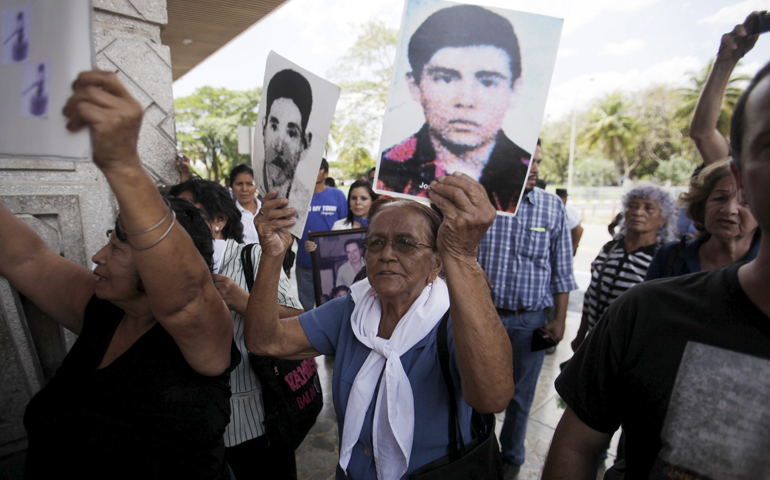 Relatives of war victims protest against retired Gen. Carlos Eugenio Vides Casanova upon his arrival April 8 at El Salvador International Airport. Casanova was deported from the United States for his alleged involvement in torture and killings during the 1979-92 civil war in El Salvador. (CNS/Reuters/Jose Cabezas)
