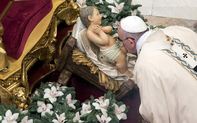 Pope Francis kisses a statue of baby Jesus during Mass Tuesday on the feast of the Epiphany in St. Peter's Basilica at the Vatican. (CNS/Reuters/Andrew Medichini, pool)