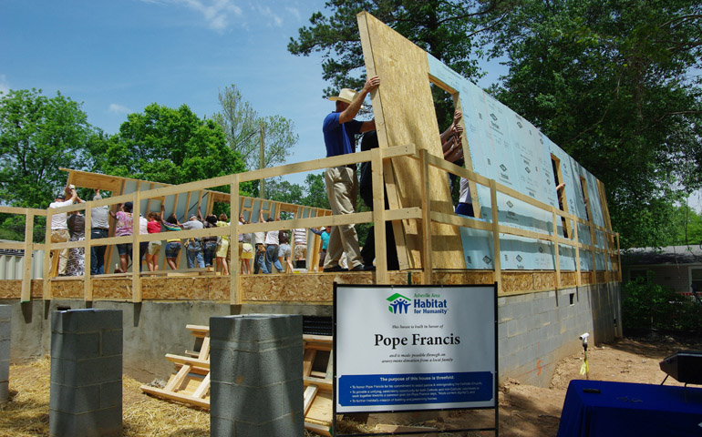 Staff, volunteers, supporters and the Meadows family raise the first two walls of the Pope Francis House on Wednesday in Asheville, N.C. (Courtesy Asheville Area Habitat for Humanity)