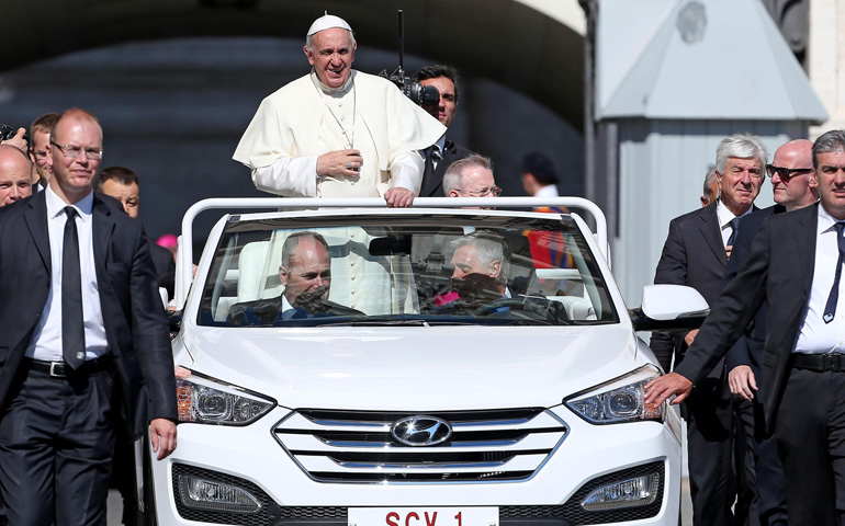 Pope Francis rides in his new popemobile during his weekly audience Wednesday in St. Peter's Square at the Vatican. (CNS/EPA/Alessandro Di Meo)