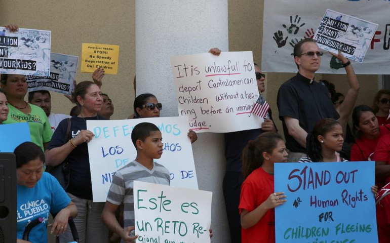 Immigrant families and immigration reform activists hold signs of protest during a news conference Monday in Washington near the White House organized by Casa de Maryland and other pro-immigration-reform groups. (CNS/Chaz Muth) 
