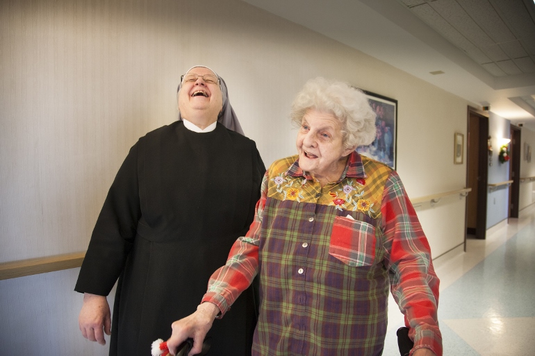 Sr. Jean Dwyan laughs with Martah Spurgeon Jan. 13 in the hallway of the St. Louis Residence of the Little Sisters of the Poor, which serves about 100 people. While the "fun, fun, fun" is a big part of the St. Louis Residence, so too are the simple acts of caring. (CNS photo/Lisa Johnston, St. Louis Review)
