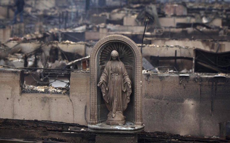 A statue of Mary stands Tuesday amid the remains of homes destroyed by fire and the effects of Hurricane Sandy in the Breezy Point section of the New York borough of Queens. More than 80 homes were destroyed in the tiny beachfront neighborhood. (CNS/Reuters/Shannon Stapleton)