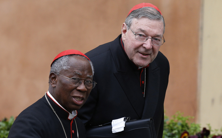 Cardinals Francis Arinze, retired prefect of the Congregation for Divine Worship and the Sacraments, and George Pell of Sydney are seen arriving for the final general congregation meeting in the synod hall at the Vatican March 11. (CNS photo/Paul Haring)