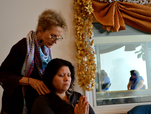 Marydale Pecora gives Sandra Delgado an energy attunement at her Reiki share session. (RNS/Brianna Sacks)