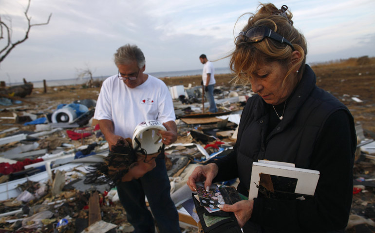 Residents look through photos Nov. 12 amid the debris of a house destroyed by Hurricane Sandy in Union Beach, N.J. (CNS/Reuters/Eric Thayer)