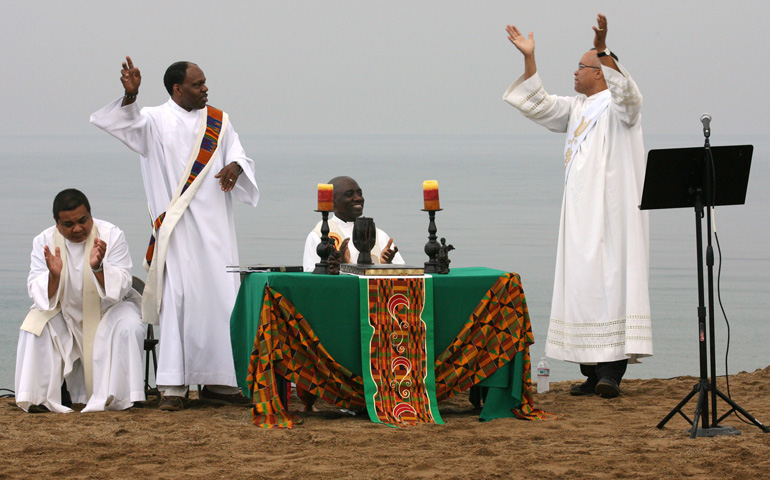 Deacon Leroy Gill and Deacon John Cook lead participants in song during a prayer service in Chicago Aug. 21, 2010. Simultaneous back to school sunrise prayer services to pray for an end to violence, the protection of children, and a successful and nonviolent school year were conducted at five Chicago becahes along the shores of Lake Michigan. (CNS/Karen Callaway)