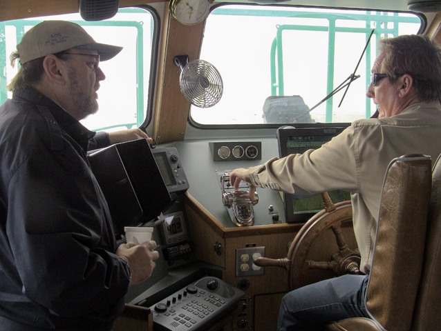 Fr. Sinclair Oubre, left, visits a pilot boat in Port Arthur, Texas, in January 2012. Oubre serves as the diocesan director and chaplain of the ports of Port Arthur and Orange in the Beaumont diocese. (Apostleship of the Sea-USA)