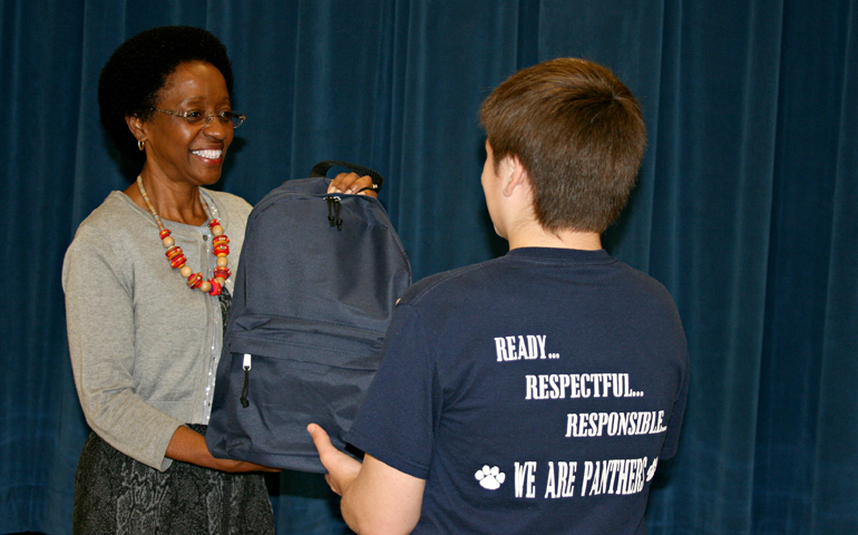 Kathy Pickett, dean at Mulberry Middle School in Mulberry, Fla., offers a student a backpack filled with a weekend supply of food through the SmilePak program.