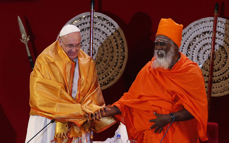 Pope Francis shakes hands with Hindu Kurukkal SivaSri T. Mahadeva after receiving a robe from him during a meeting Tuesday with religious leaders at the Bandaranaike Memorial International Conference Hall in Colombo, Sri Lanka. (CNS/Paul Haring)