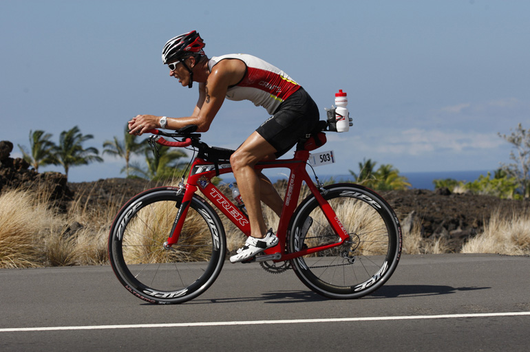 Fr. Thomas Baker, pastor of Sacred Heart Church in Lancaster, Calif., rides his bike during the Ironman World Championship in Kona, Hawaii, Oct. 13. Baker conquered a windy course in Kona, crossing the finish line with a time of 13:33:36. (CNS/Courtesy Thomas Baker)