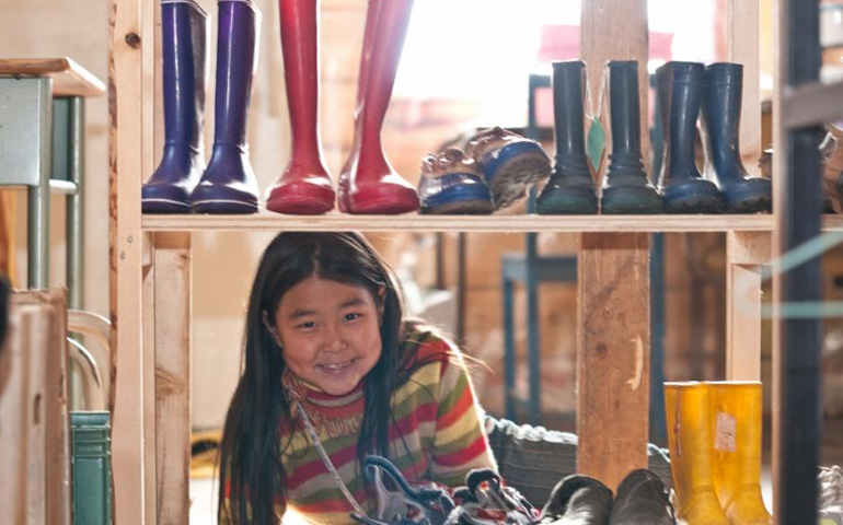 An Inuvialuit girl pictured July 2, 2011, smiles inside the Saint Vincent de Paul thrift store that Sr. Fay Trombley started to provide affordable clothing in Tukoyaktuk. (Michael Swan, used under Creative Commons 2.0)