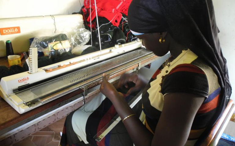 Alima Sauda was a student at the Santa Monica Girls Tailoring School, but now she works as a staff member to teach other girls to weave. Here, she makes school uniform sweaters on a weaving machine. (Melanie Lidman)