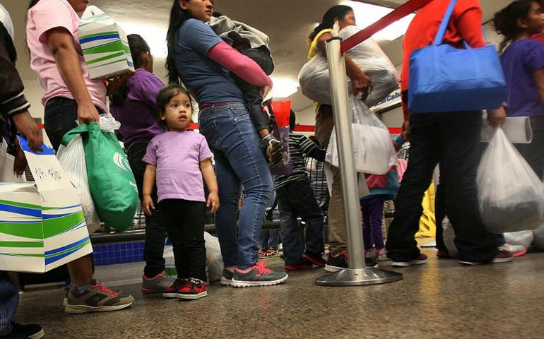 Genesis Pagoada, 2, of Honduras stands in line with other immigrant families released from a detention center July 14 in Dilley, Texas, at the Greyhound Bus Station in San Antonio. (GSR photo/Nuri Vallbona)
