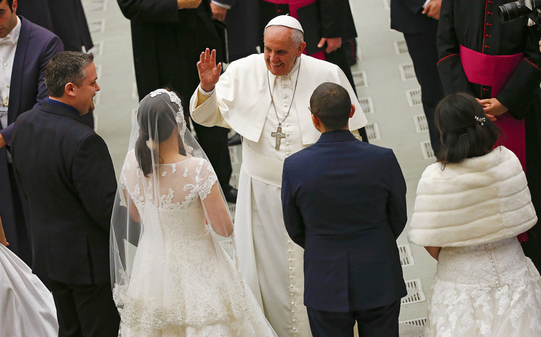 Pope Francis gestures to newlywed couples during his weekly audience Wednesday in Paul VI hall at the Vatican. (CNS/Reuters/Tony Gentile)