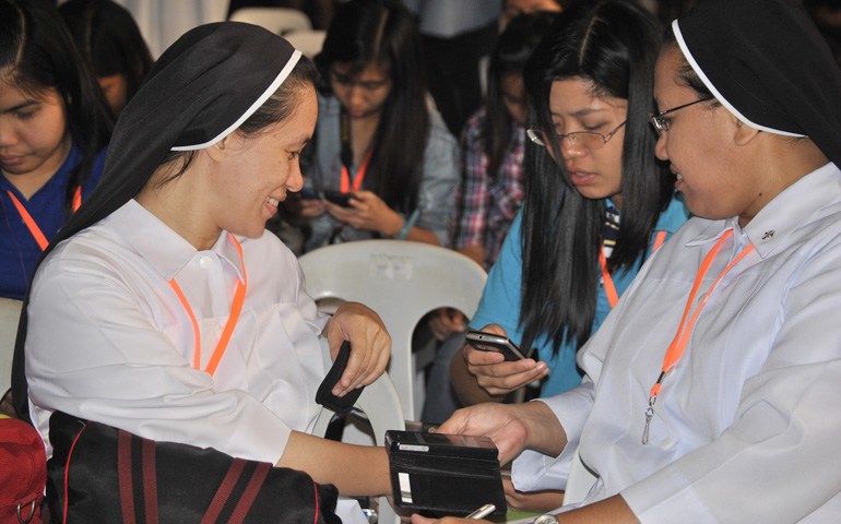 Dominican Sr. Grace Tagnipez, right, tweets for an exercise during the Nov. 23-24 Catholic Social Media Summit at San Juan de Letran College in Manila. (N.J. Viehland)