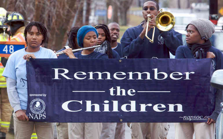 Young people play music outside the funeral Mass for Rachel Marie D'Avino at the Church of the Nativity in Bethlehem, Conn., Dec. 21. D'Avino was among the 20 schoolchildren shot dead Dec. 14 after a gunman forced his way into Sandy Hook Elementary Schoo l in Newtown. (CNS photo/Michelle McLoughlin, Reuters)