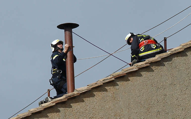 Vatican firefighters secure a smokestack on the roof of the Sistine Chapel at the Vatican March 9 (CNS/Paul Haring)