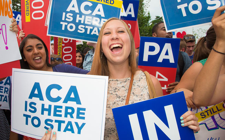 Demonstrators cheer in support of the Affordable Care Act outside the U.S. Supreme Court in Washington, D.C., June 25, 2015. (Newscom/Jeff Malet)