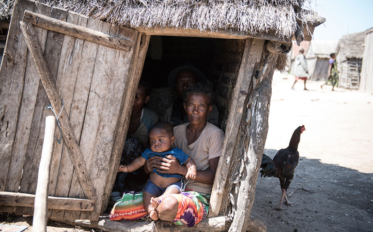 A family sits inside their hut in Ambovombe, Madagascar, Sept. 22, 2015. (CNS/EPA/Shiraaz Mohamed)