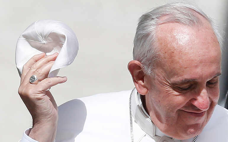 Pope Francis holds his skullcap as he arrives to lead his Wednesday general audience in St. Peter's Square at the Vatican on May 22, 2013. (Photo courtesy of Reuters/Tony Gentile)