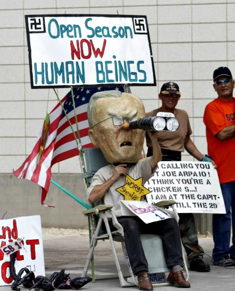 A man wears a mask of Joe Arpaio, then-sheriff of Maricopa County, during a protest against S.B. 1070, Arizona's immigration law, outside the U.S. District Court in Phoenix in 2010. (CNS/Reuters/Joshua Lott)