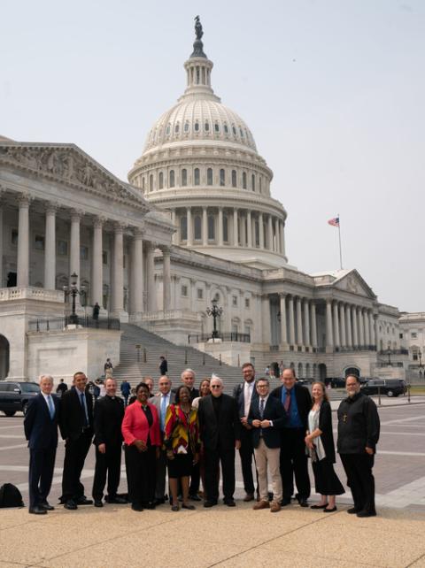 Delegation members assembled, smiling with Capitol building in background