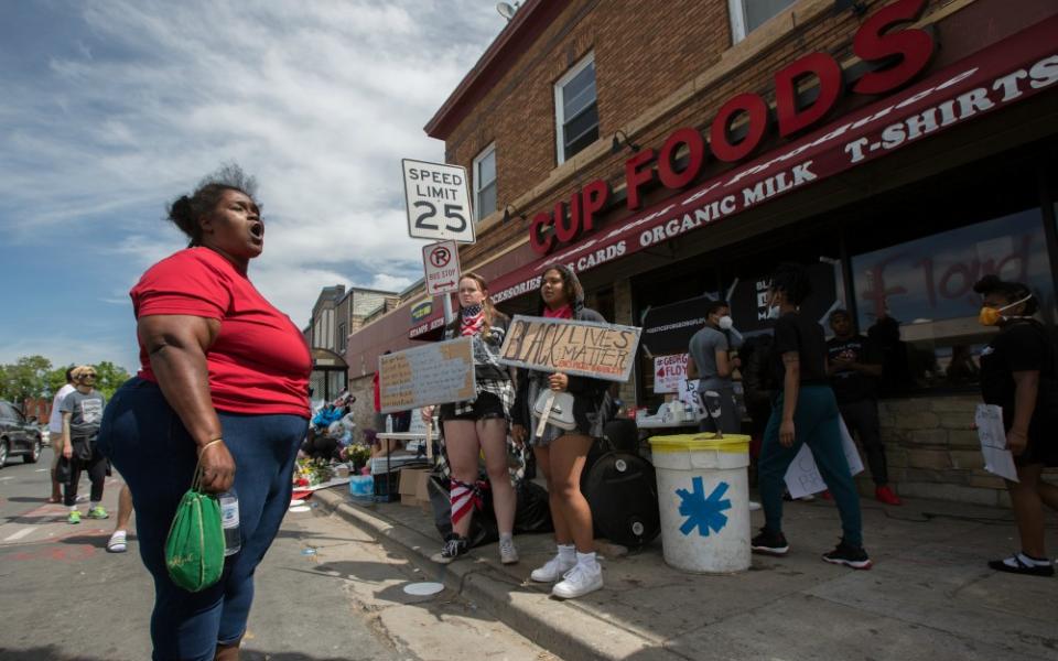 A woman in Minneapolis expresses her anger and frustration May 28 at the site where George Floyd was pinned down May 25 by a police officer. Floyd later died at a local hospital. (CNS/The Catholic Spirit/Dave Hrbacek)