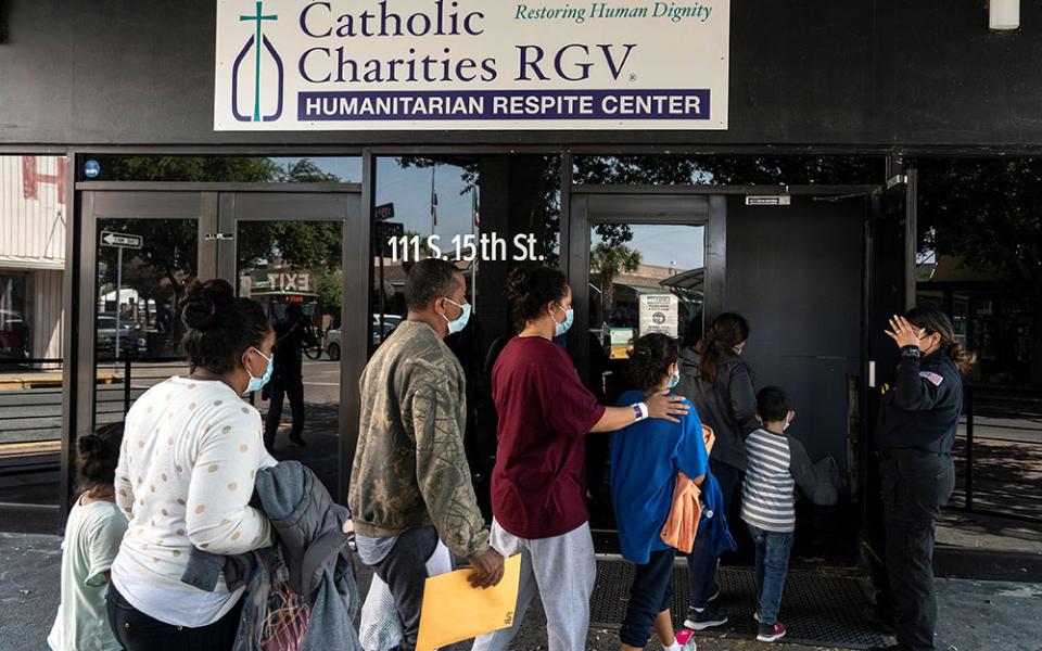 Migrants seeking asylum in the U.S. walk into a temporary humanitarian respite center run by Catholic Charities of the Rio Grande Valley in McAllen, Texas, April 8. (CNS/Reuters/Go Nakamura)