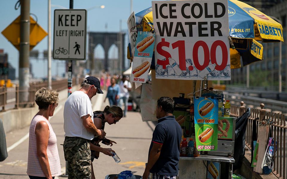 People on the Brooklyn Bridge in New York City buy cold water during a heat wave June 30. (CNS/Reuters/Eduardo Munoz)