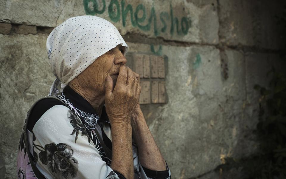 An elderly Ukrainian woman looks on after Russian shelling in Mykolaiv, Ukraine, June 29. (AP/George Ivanchenko)