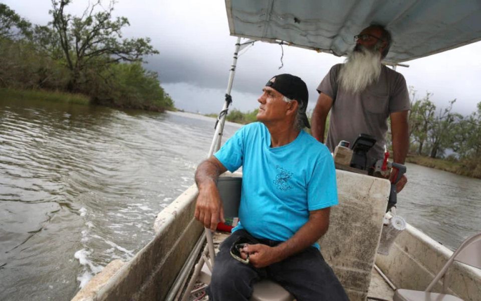 Donald Dardar, left, and Russell Dardar look toward the eroding shoreline of Bayou Pointe-au-Chien in southern Louisiana on Wednesday, Sept. 29, 2021. (AP/Jessie Wardarski)