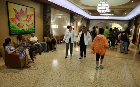 Medical staff and others walk through the hallway of Mutual Help Catholic Hospital in San Juan, Puerto Rico, in 2017. (CNS/Bob Roller)