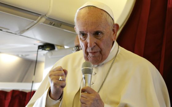 Pope Francis answers questions from journalists aboard his flight from Rabat, Morocco, to Rome March 31. (CNS/Paul Haring)