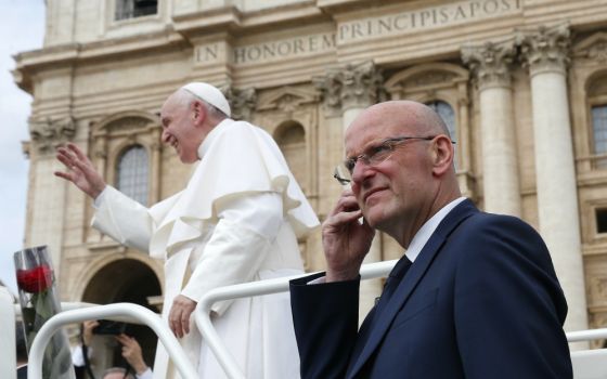 Domenico Giani, lead bodyguard for Pope Francis and head of the Vatican police force, keeps watch as the pope leaves his general audience in St. Peter's Square at the Vatican May 1. Pope Francis accepted Giani's resignation Oct. 14. (CNS/Paul Haring)