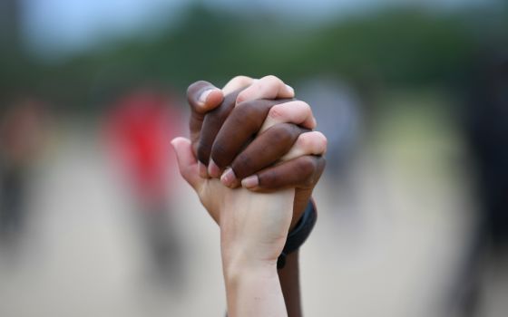 A man and woman hold hands in London's Hyde Park during a Black Lives Matter protest June 3. (CNS/Reuters/Dylan Martinez)