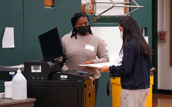A poll worker looks on as a voter casts her ballot on Election Day Nov. 3, 2020, at William S. Mount Elementary School in Stony Brook, New York. (CNS/Gregory A. Shemitz)