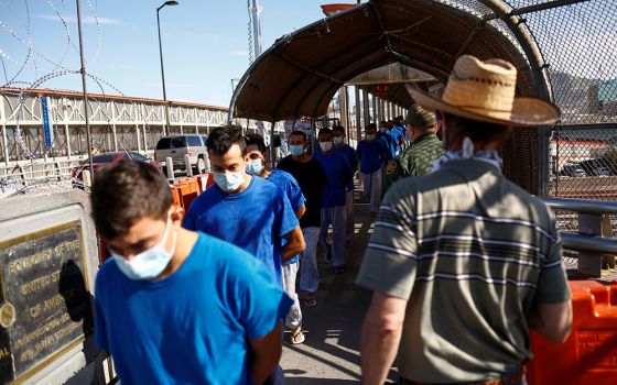 Migrants expelled from the U.S. and sent back to Mexico under Title 42 walk toward Mexico at the Paso del Norte International border bridge July 29, in this picture taken from Ciudad Juarez, Mexico. (CNS/Reuters/Jose Luis Gonzalez)