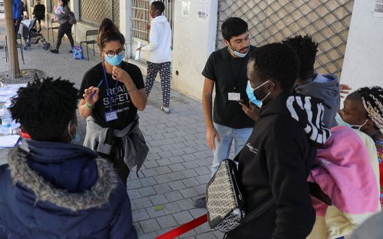 Volunteers assist migrants outside Holy Cross Catholic Church next to the United Nations buffer zone in Nicosia, Cyprus, Nov. 24. (CNS/Reuters/Yiannis Kourtoglou)