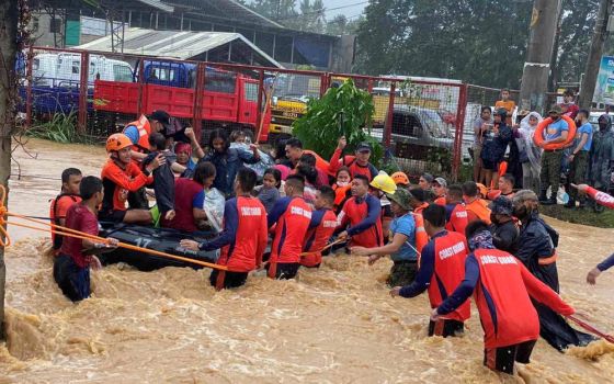 Philippine Coast Guard personnel rescue residents stranded by floods caused by Typhoon Rai in Cagayan de Oro, Philippines, Dec. 16, 2021. As of Dec. 21, the storm had claimed more than 370 lives. (CNS photo/Philippine Coast Guard handout via Reuters)