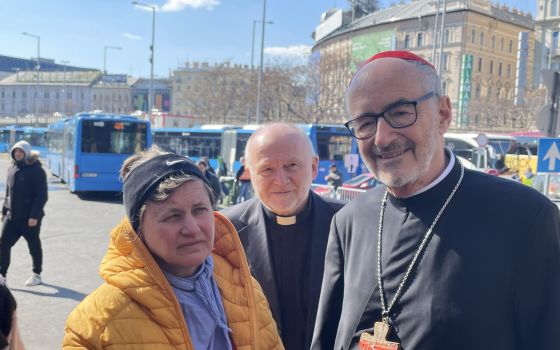 Cardinal Michael Czerny, interim president of the Dicastery for Promoting Integral Human Development, and Jesuit Father Sajgó Szabolcs from Jesuit Refugee Service, speak to a refugee who fled Odessa, Ukraine, and arrived at the Nyugati train station in Bu