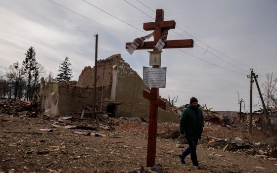 A man walks by the debris of a cultural center and an administration building destroyed during aerial bombing, as Russia's advance on the Ukrainian capital continues, in the village of Byshiv outside Kyiv, Ukraine, March 12, 2022. (CNS photo/Thomas Peter,