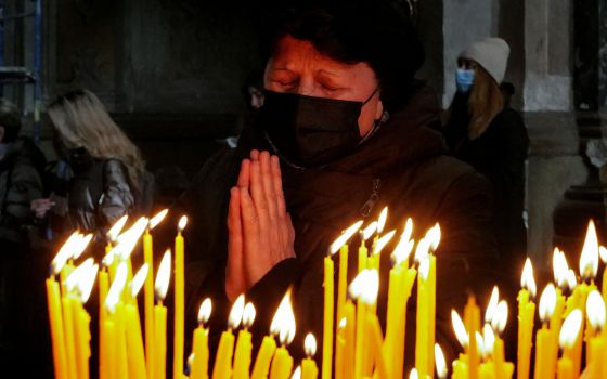 A woman prays at the Catholic Church of the Holy Apostles Peter and Paul in Lviv, Ukraine, March 20, 2022, during Russia's invasion of Ukraine. (CNS photo/Zohra Bensemra, Reuters)