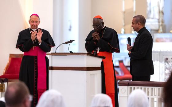 Baltimore Archbishop William E. Lori, left, leads a round of applause for Guinean Cardinal Robert Sarah May 15, 2022. (CNS photo/Kevin J. Parks, Catholic Review)