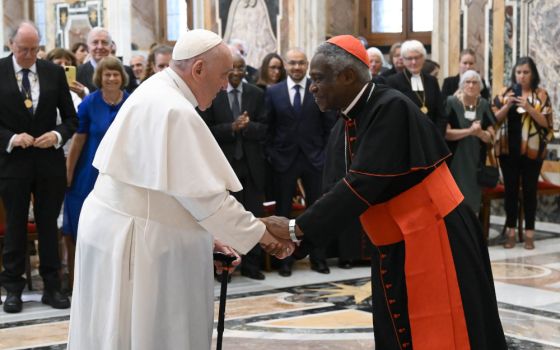 Pope Francis greets Cardinal Peter Turkson, chancellor of the Pontifical Academy of Sciences and the Pontifical Academy of Social Sciences, during an audience with members of the Pontifical Academy of Sciences at the Vatican Sept. 10, 2022. 