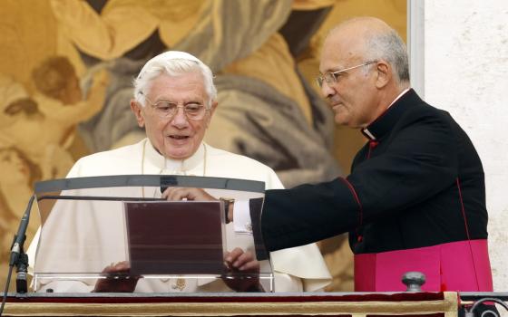 Pope Benedict XVI is assisted by his assistant personal secretary, Msgr. Alfred Xuereb, as he prepares to lead the Angelus from a window at the papal summer residence in Castel Gandolfo, Italy, Aug. 15. (CNS photo/Giampiero Sposito, Reuters) (Aug. 15, 2012) See POPE-ASSUMPTION Aug. 15, 2012.