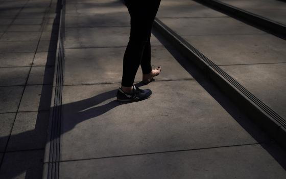 A half-barefooted homeless man walks up the steps April 14, 2022, in Los Angeles. (AP photo/Jae C. Hong)