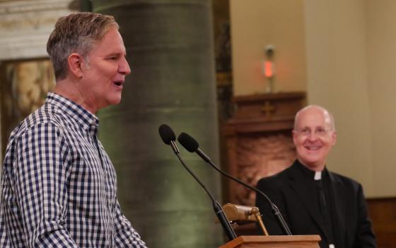 Juan Carlos Cruz, a member of the Pontifical Commission for the Protection of Minors, speaks to the Outreach conference June 18 as Jesuit Fr. James Martin looks on. (Courtesy of America Media/Cristobal Spielmann)