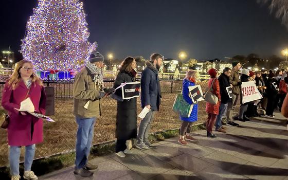 Christian protesters hold ceasefire signs while standing between the National Christmas Tree and the White House in Washington, D.C., Dec. 11. (NCR photo/Aleja Hertzler-McCain)