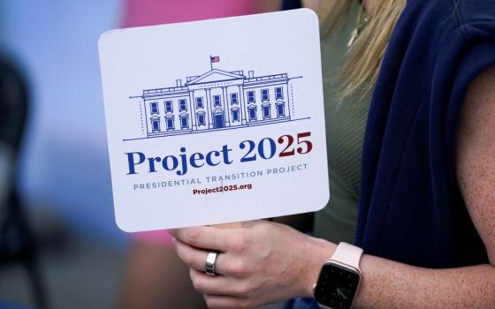 Kristen Eichamer holds a Project 2025 fan in the group's tent at the Iowa State Fair, Aug. 14, 2023, in Des Moines, Iowa.